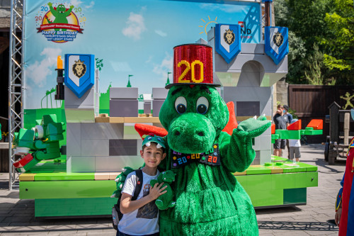 Parkmaskottchen Drache Olli im Geburtstags-Outfit mit seinem größten Fan.